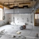 Unfinished interior under construction with exposed electrical cables hanging from the ceiling and building materials across the floor.
