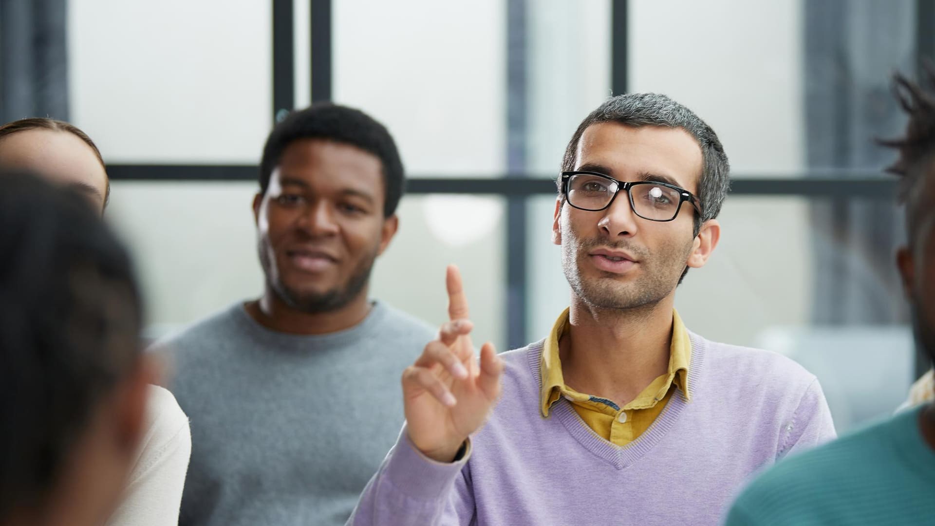 Resources > FAQs > Header > Background Adult learner contributing to a group discussion during a classroom training session.