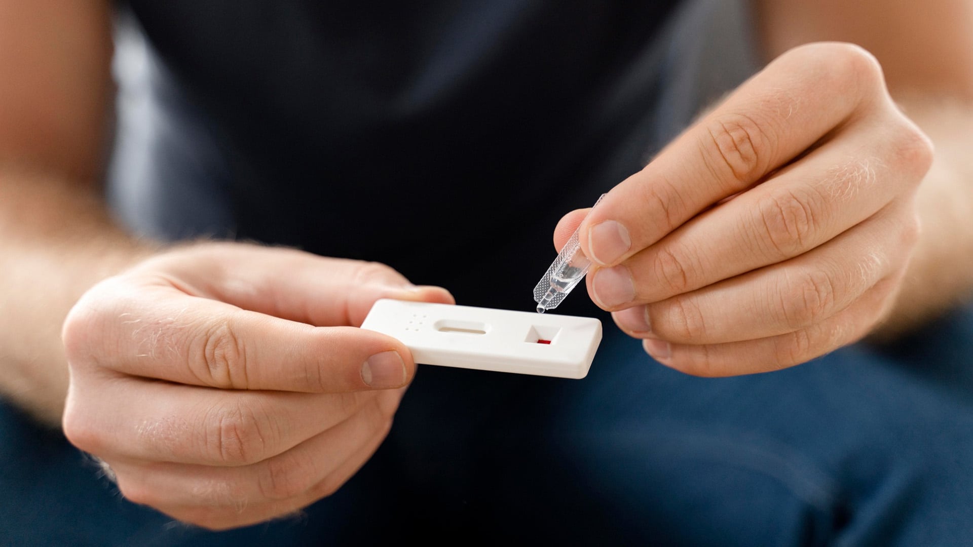 Services > Drug and Alcohol Testing > Header > Background Person using a rapid lateral flow test kit to apply a liquid sample.